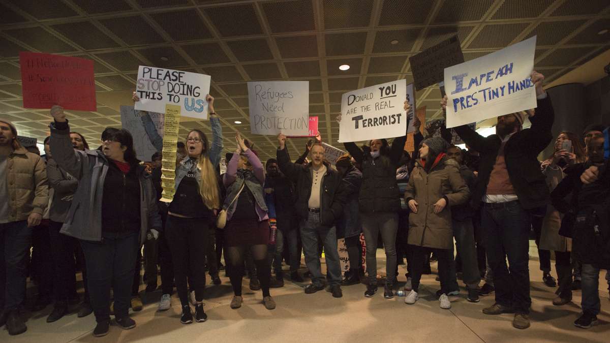 Protesters chant slogans inside the terminal at Philadelphia International Airport. (Branden Eastwood for NewsWorks)
