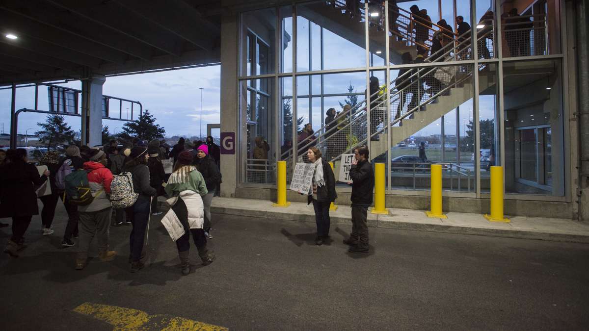 Protesters who had been denied entry into the terminal search for another way into the airport. (Branden Eastwood for NewsWorks)