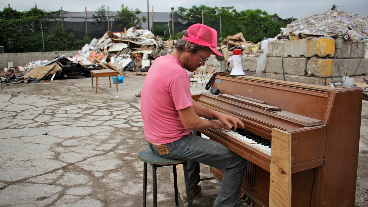 Artist Billy Dufala plays a resurected piano at Revolution Recovery recycling dump, where he oversees an artist-in-residency program that uses the dump as a performance space and source of materials and inspiration. (Emma Lee/WHYY)