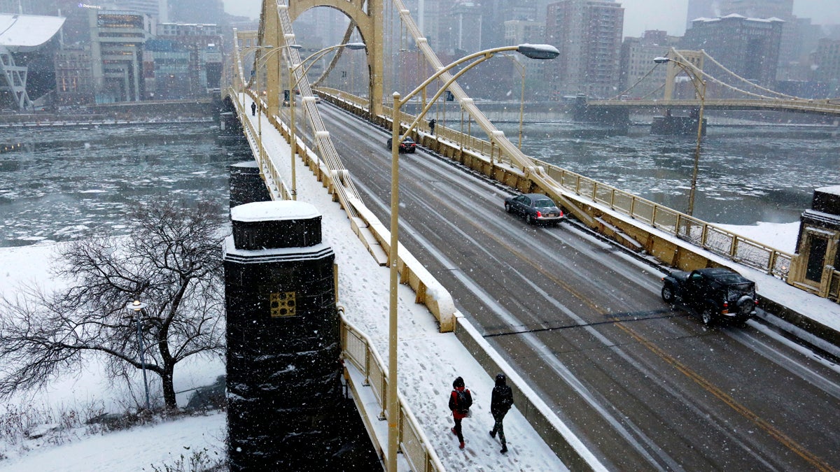  People walk across the Rachel Carson bridge across the Allegheny River toward downtown Pittsburgh as snow falls, Wednesday, Jan. 20, 2016. (AP Photo/Gene J. Puskar) 