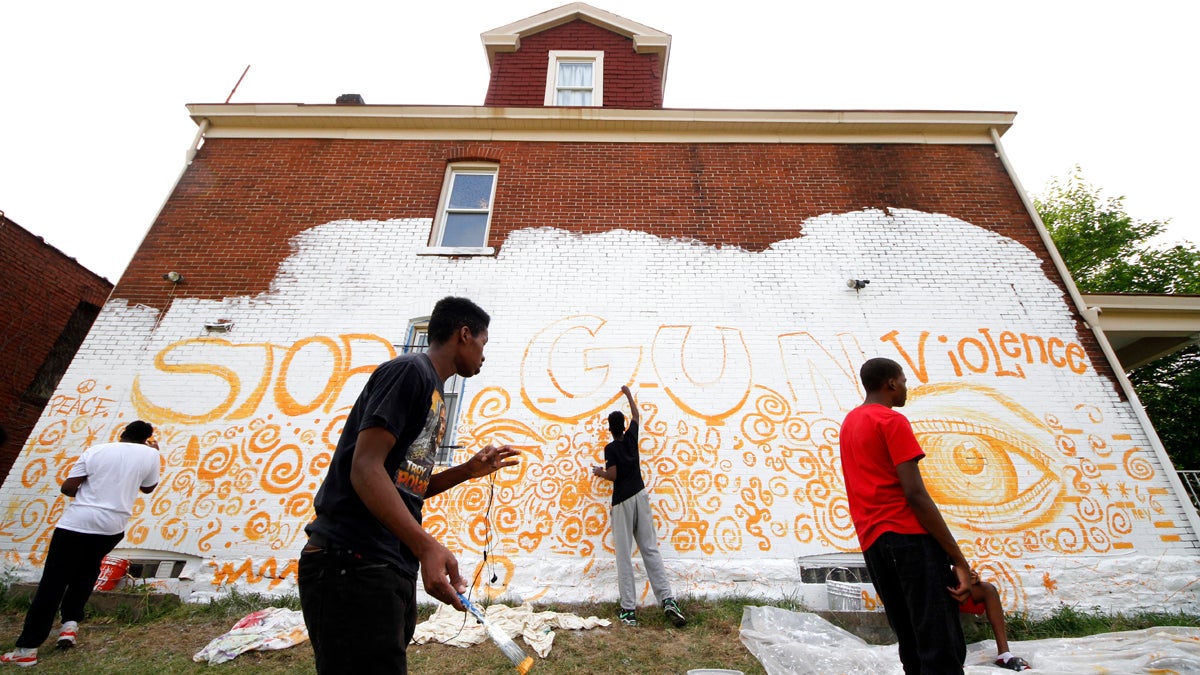  Young adult artists in the Homewood section of Pittsburgh paint a mural on the side of a building as part of a community wide 10 mural project organized by Moving the Lives through its Community Mural Project Wednesday, July 13, 2016. (AP Photo/Gene J. Puskar) 