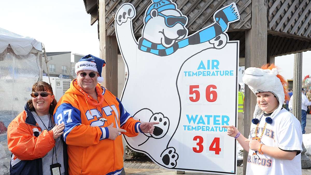 Some Broncos fans in a happier time on Super Bowl Sunday before the game pointing out the very mild air temperature at 56 degrees, compared to the chilly water temperature at 34 degrees. (Chuck Snyder/for NewsWorks)