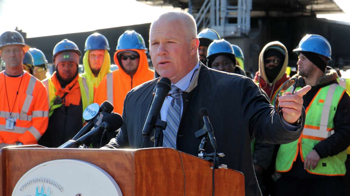 Leo Holt of Holt Logistics, which invested more than $12 million at the site, speaks as dozens of dock workers gather behind him. (Emma Lee/WHYY)