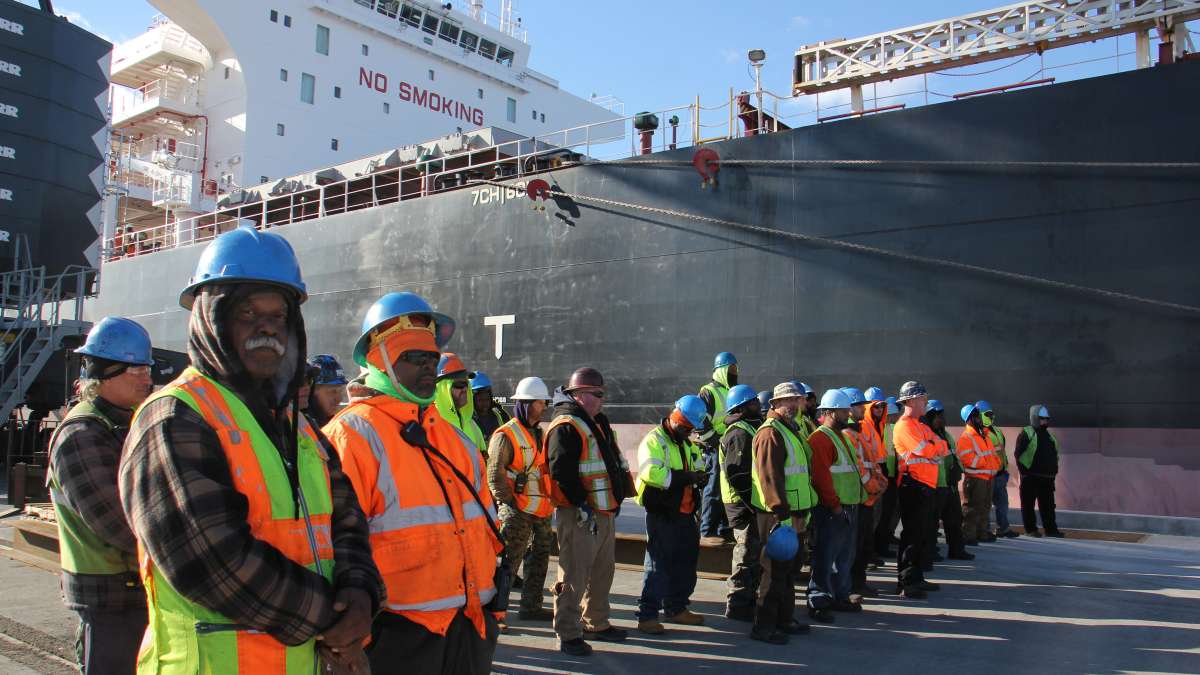Dockworkers stand beside massive ship Doric Warrior, ready to unload its cargo of steel at the Paulsboro Marine Terminal. (Emma Lee/WHYY)