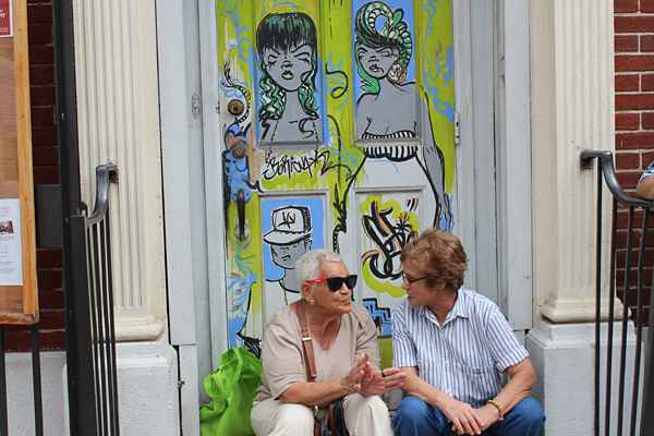 A conversation among friends at the foot of two graffiti women. (Elisabeth Perez-Luna
