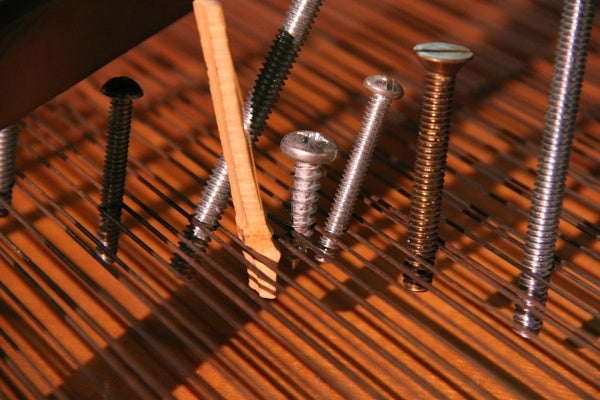 <p>Bolts and screws of various types and sizes, pieces of wood and bits of rubber are arranged among the strings of a grand piano at the Philadelphia Art Museum according to composer John Cage's specific instructions. (Emma Lee/for NewsWorks)</p>
