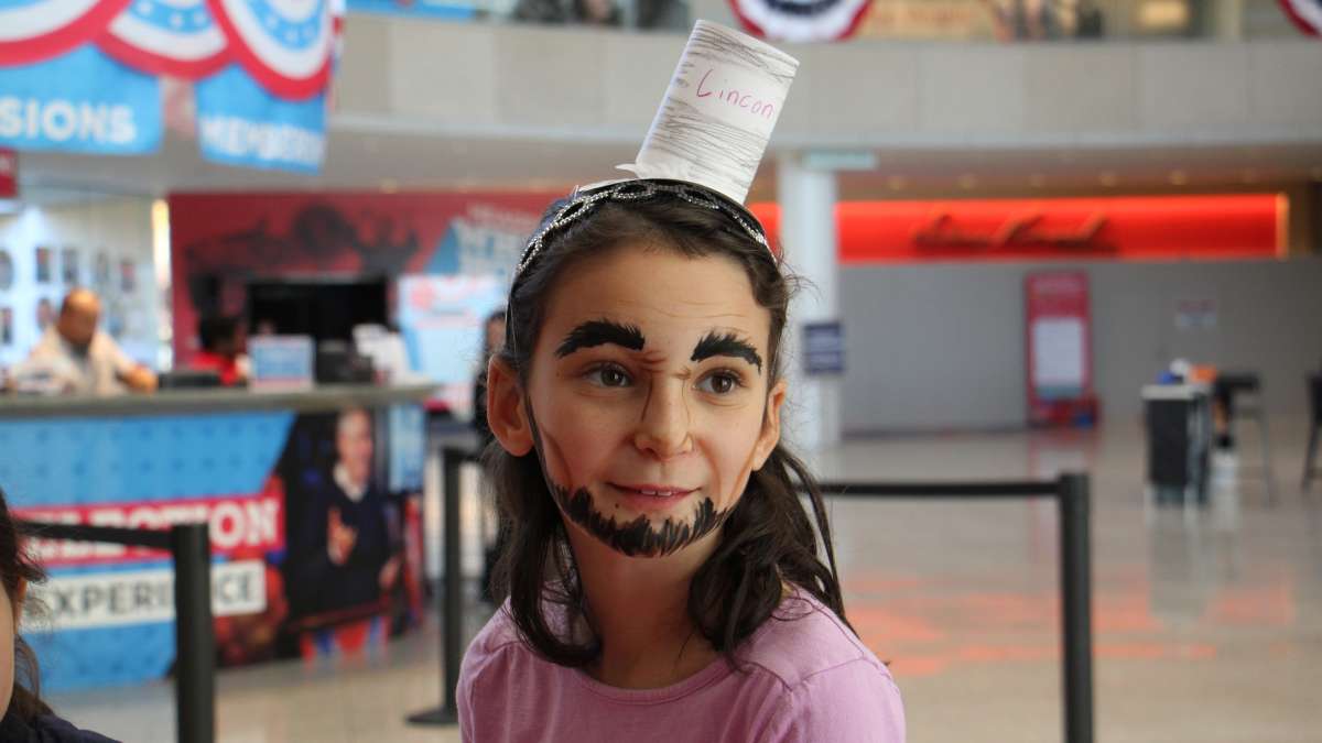 A yount Abraham Lincoln portrayer transforms her appearance with artful face paint during an Election Day visit to the National Constitution Center.