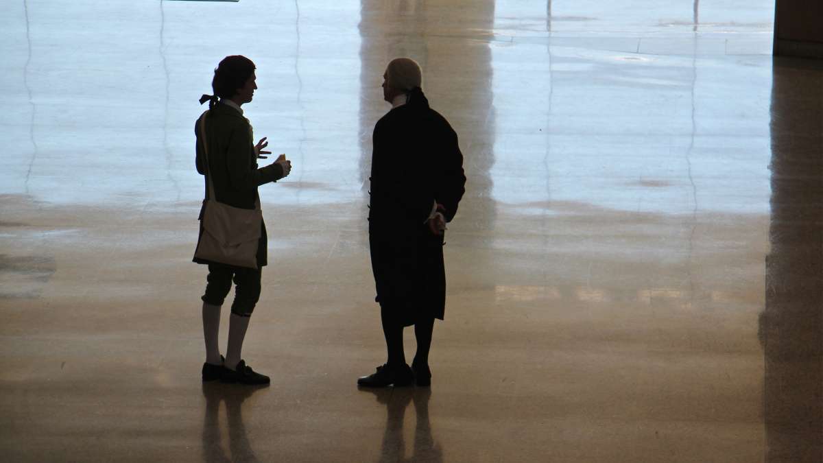 Historic Philadelphia presidential portrayers Sean Connolly (left) and John Lopes talk on the floor of the National Constitution Center's Grand Hall Lobby during Election Day festivities.