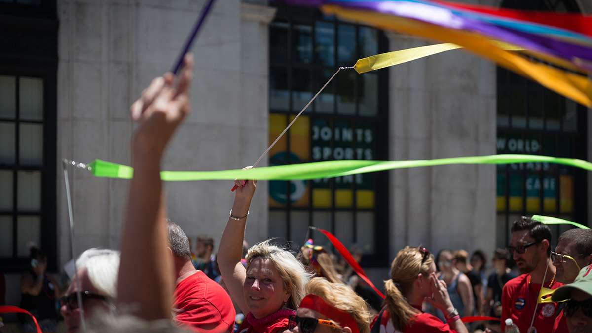 Jan Monaghan and other employees of General Electric wave streamers at Philadelphia Pride Parade and Festival. (Branden Eastwood for NewsWorks)