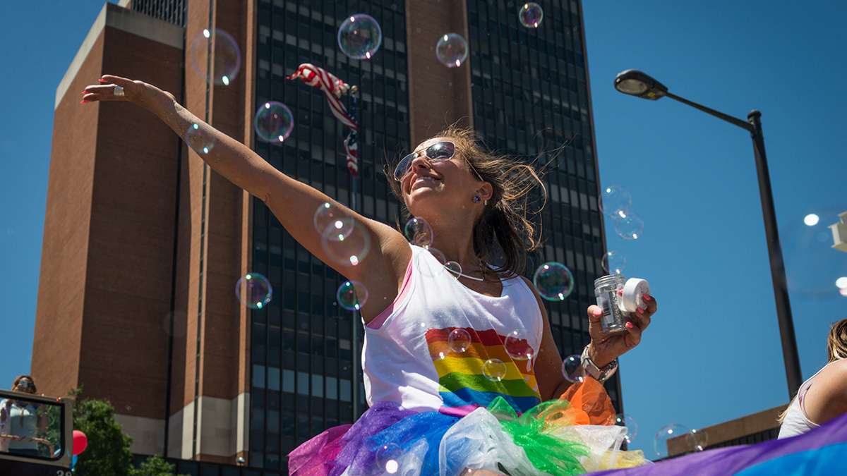 Erin Cooper is surrounded by bubbles while riding on the Zip Car float at Philadelphia Pride Parade and Festival. (Branden Eastwood for NewsWorks)
