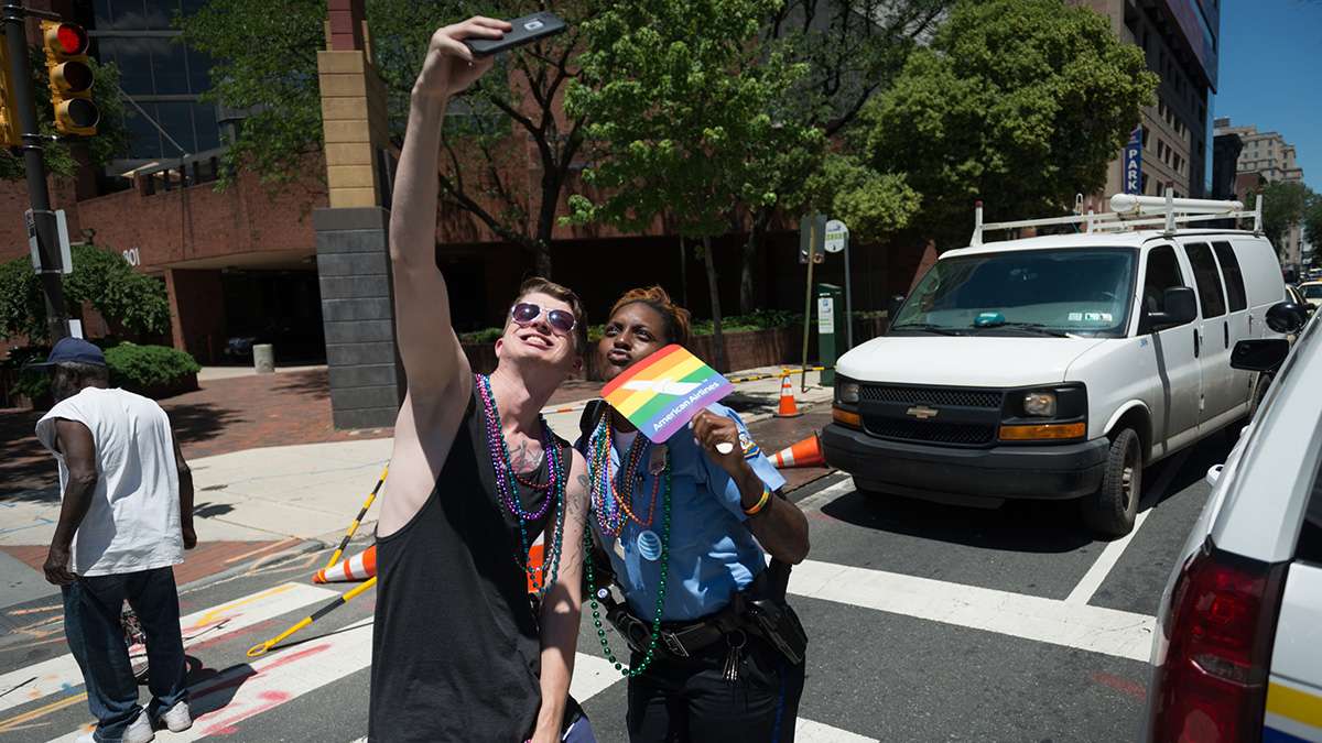 Jamecia Pierce of the Philadelphia Police Department poses for a selfie along the Pride parade route. (Branden Eastwood for NewsWorks)