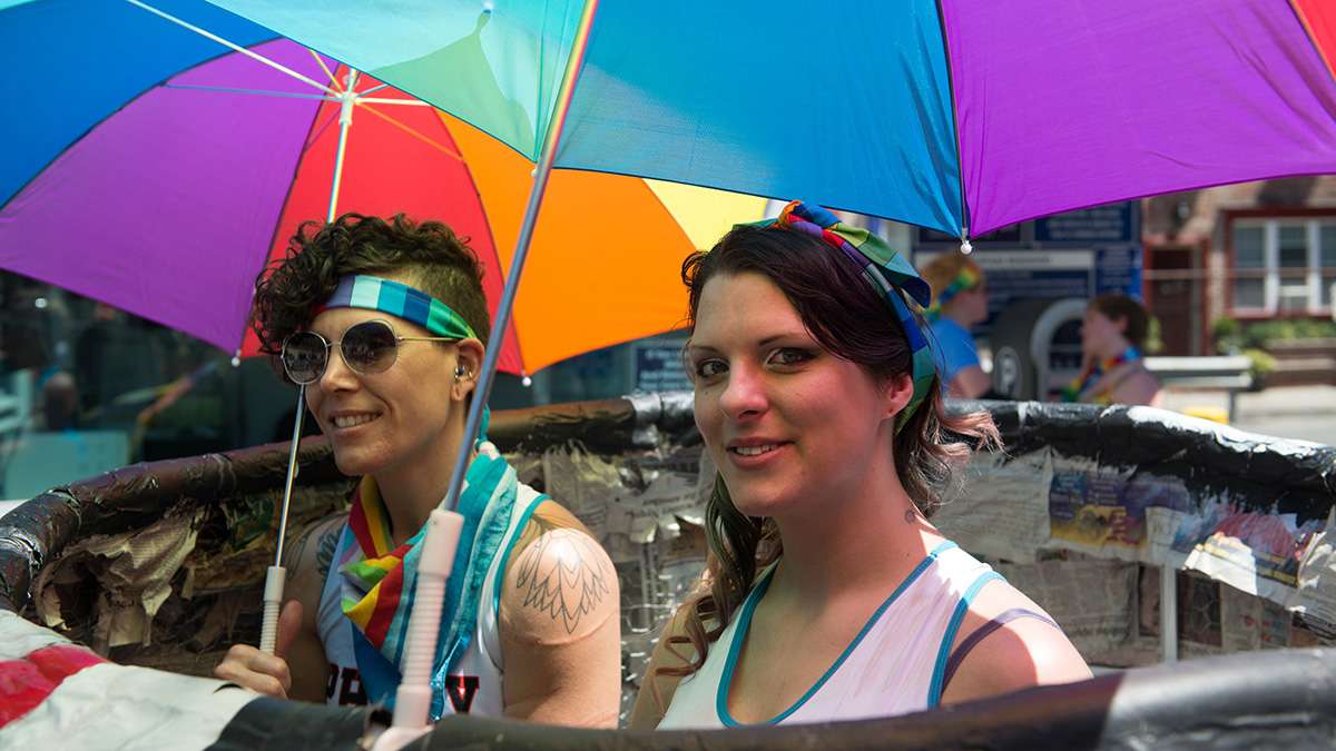 Mishel Castro (left) and Leah Yancoskie pose for a photo near Locust Street while participating in the Philadelphia Pride Parade and Festival. (Branden Eastwood for NewsWorks)