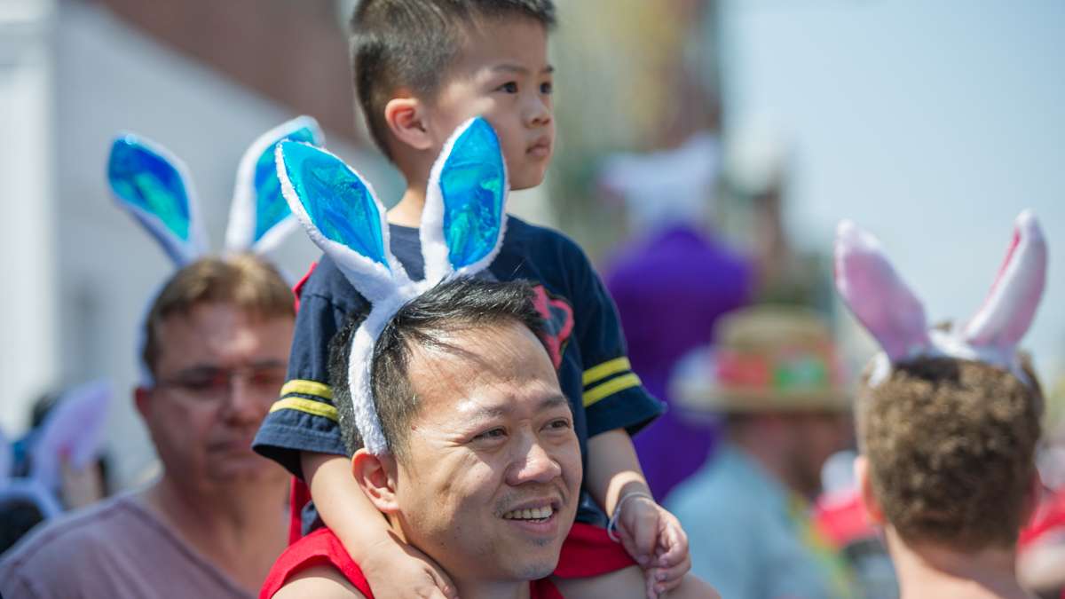 Benjamin Nguyen holds his son, Levi, aloft to view the parade.
