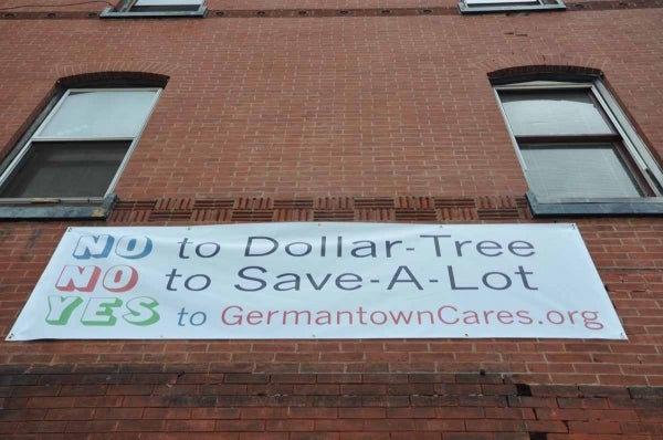 A banner protesting Chelten Plaza recently displayed on a building acrross the street from the site. (Kristen Mosbrucker/for NewsWorks)