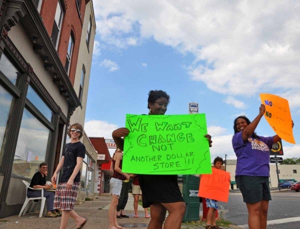 Michele Dixon (left) and Shannon Paige Overland (right) hold signs on the corner of Chelten and Pulaski. (Kristen Mosbrucker/for NewsWorks)