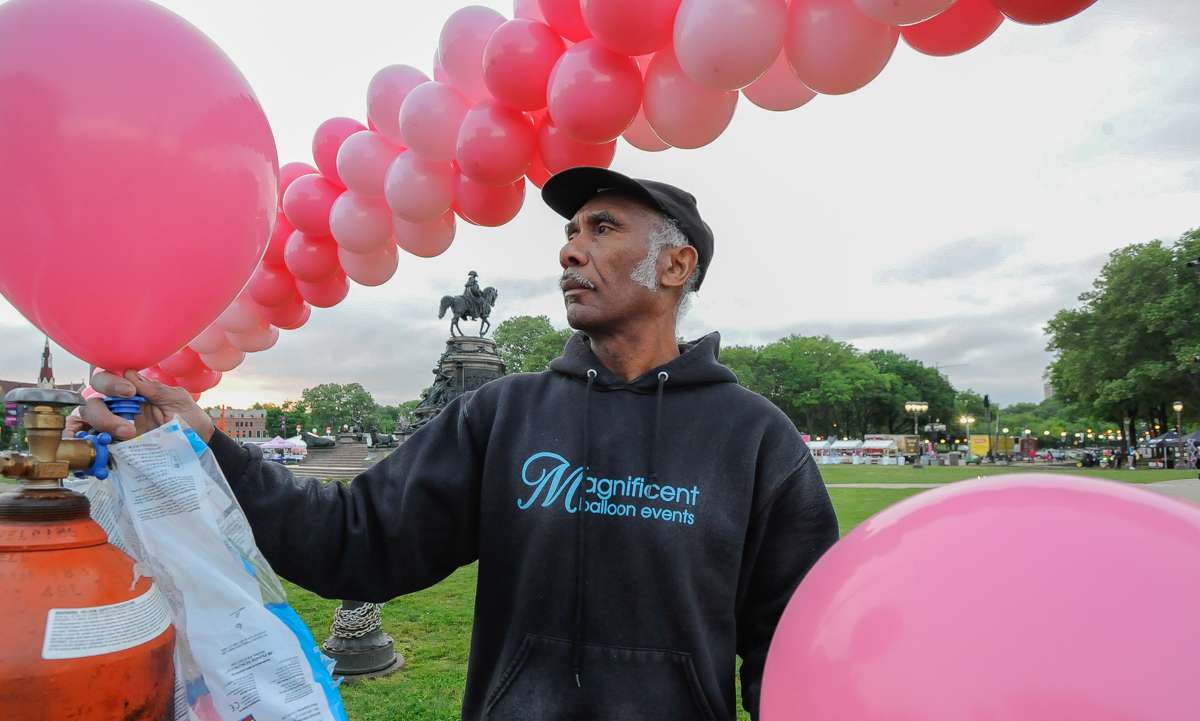 Noel Murray blows up balloons for the balloon arches that cancer survivors walk through on the steps of the Philadelphia Museum of Art.