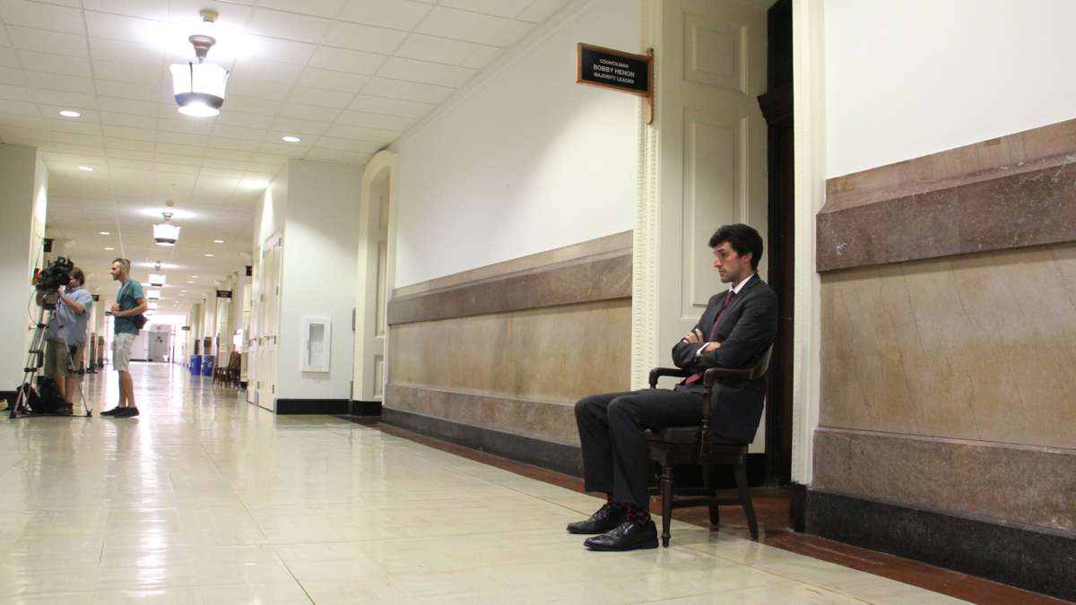 An FBI agent sits guard in front of the City Hall office of Councilman Bobby Henon. (Emma Lee/WHYY)