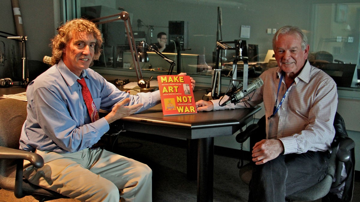  Dave Heller and Ralph Young at WHYY studios with Young's book, 'Make Art, Not War: Political Protest Posters from the 20th Century.' (Emma Lee/WHYY) 