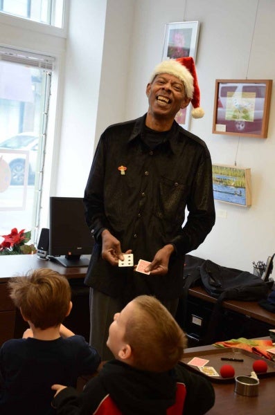 <p><p>Lamont Samuel, also known as Mr. Magic, shares a laugh with children attending RDC's holiday party on Saturday. (Jimmy Viola/for NewsWorks)</p></p>
