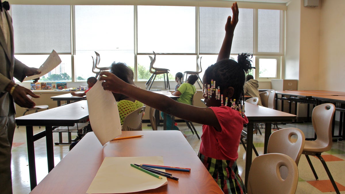  Fourth grader Charlene Brown raises her hand during a summer reading class at West Philadelphia High School. (Emma Lee/WHYY) 