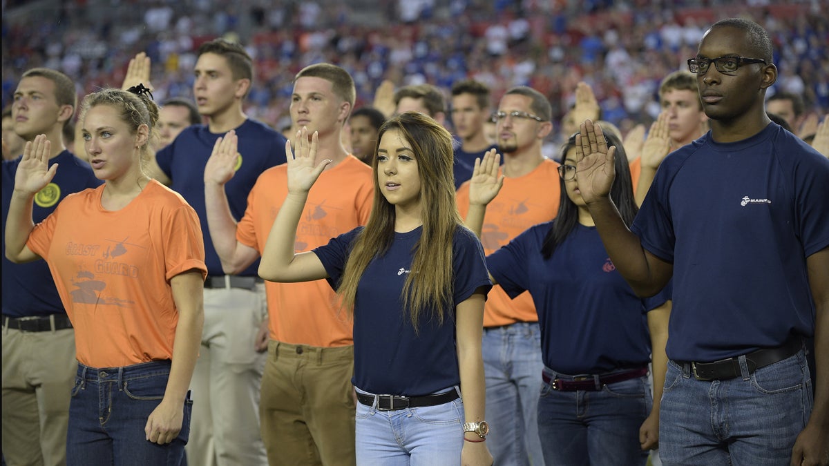  New military recruits take an oath during half time of an NFL football game between the Tampa Bay Buccaneers and the New York Giants Sunday, Nov. 8, 2015, in Tampa, Fla. (AP Photo/Phelan M. Ebenhack) 