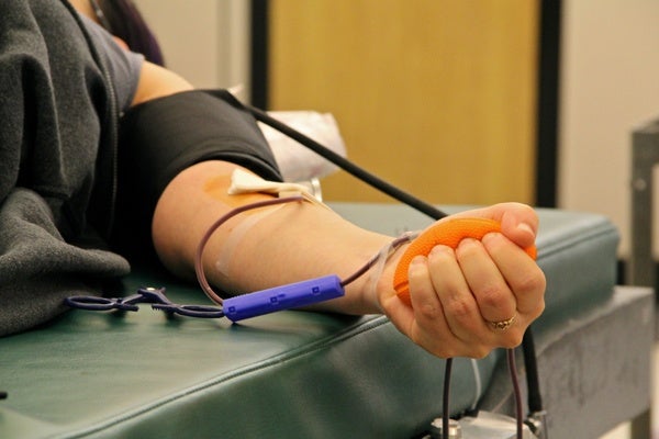 <p>Orli Gal of Philadelphia squeezes a rubber ball as she donates a pint of blood at the American Red Cross donation center. (Emma Lee/for Newsworks)</p>
