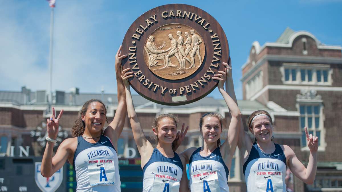 The triumphant Villanova women's 4-by-1500 relay team hold their plaque aloft after winning the event.