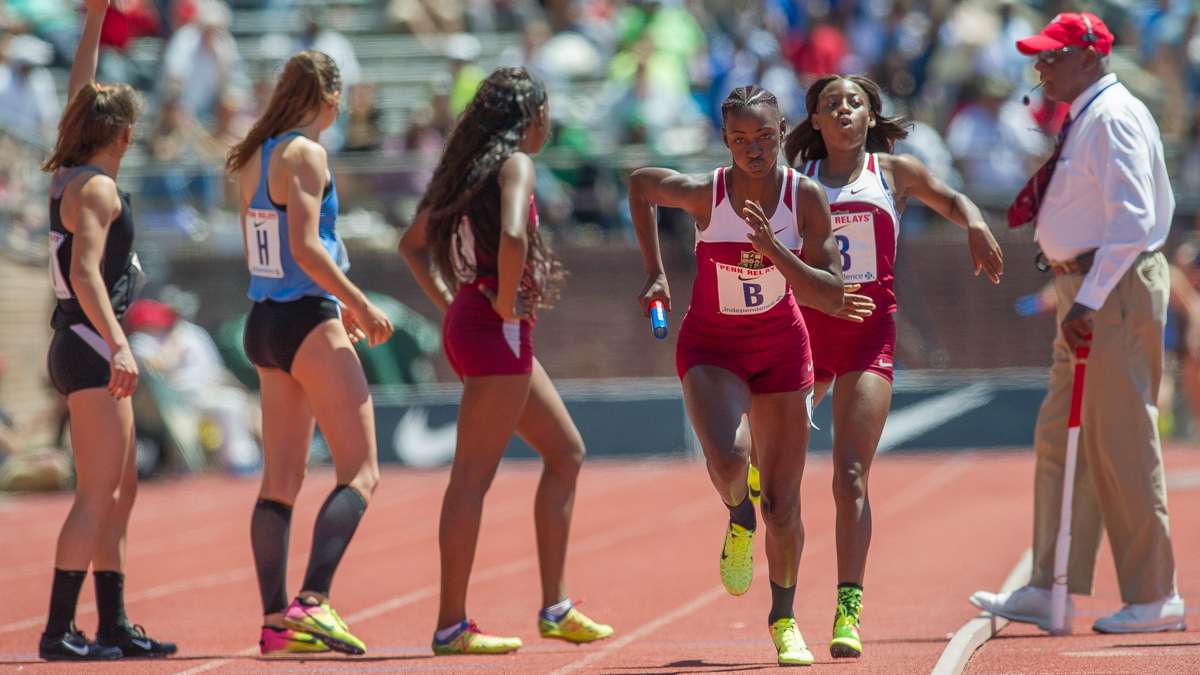 Edwin Allen's Shellece Clarke passes the baton to Patrice Moody in the anchor leg of the high school girls' 4-by-100 Championship of America. The team from Clarendon, Jamaica, won the race with a Penn Relays record time of 43.96 seconds.