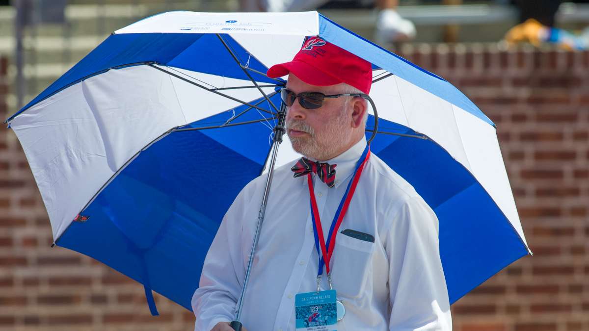 With temperatures in the mid-80s, long and triple jump official Eric J. Miller keeps the sun off.