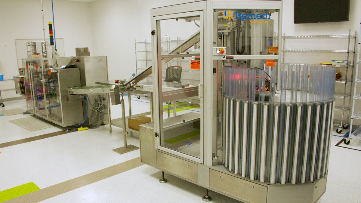  This machine loads individual pills into custom-designed packaging — labeling, sealing and loading the pills into large plastic 'magazines' (at right). (Nathaniel Hamilton/for NewsWorks) 