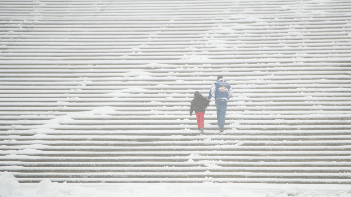Snow and sleet did not deter two members of the Huerta family, visiting from Houston, from running up the Rocky steps during the winter storm in Philadelphia on Tuesday, March 14, 2017. (Jonathan Wilson for Newsworks) 