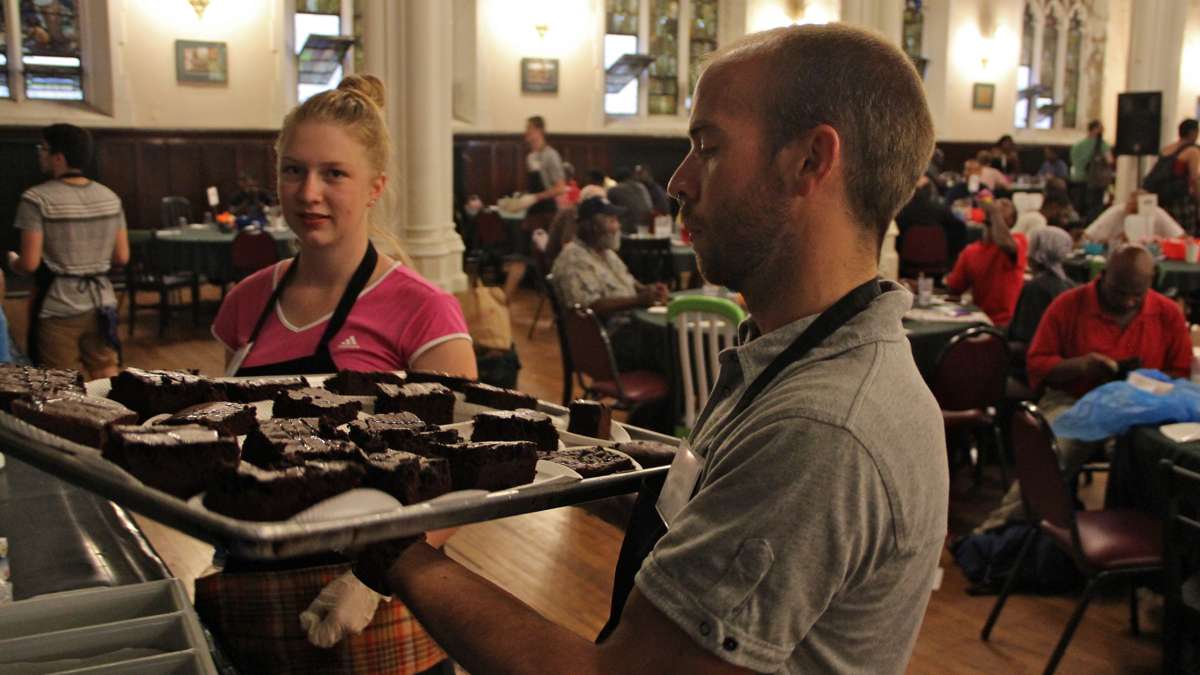 Volunteer waiters at the Broad Street Ministry carry trays to the diners. (Emma Lee/WHYY)