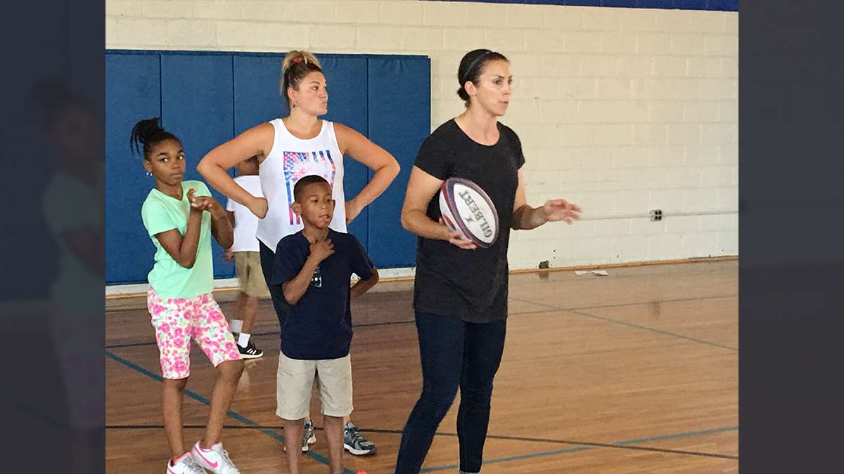 Rugby clubsCoach Kate Hallinan (center), from the Philadelphia Women’s RFC, leads a passing drill during a Rugby camp at the Northeast Frankford Boys & Girls Club (Jay Scott Smith / WHYY)