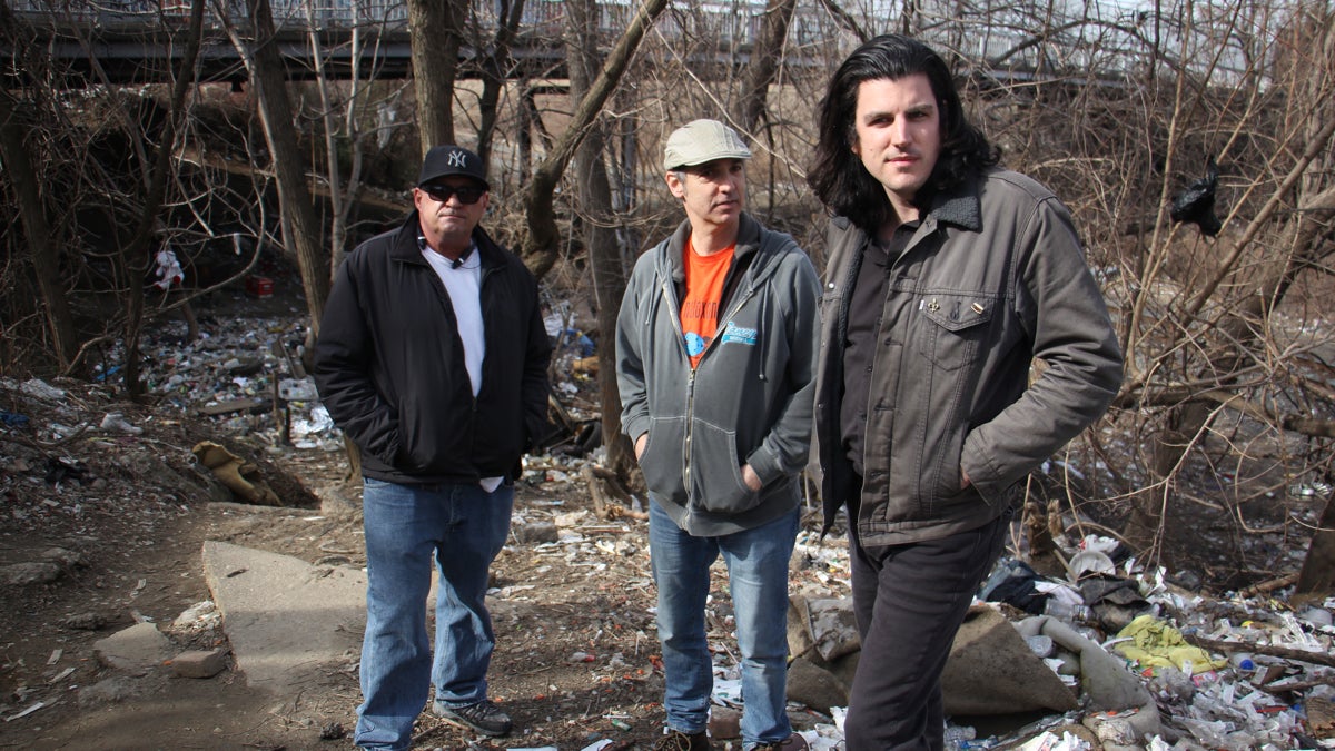  At a heroin camp in Kensington,  activists (from left) Paul Yabor, Paul Cherashore and Dan Martino make the case for safe injection sites in the city. (Emma Lee/WHYY) 