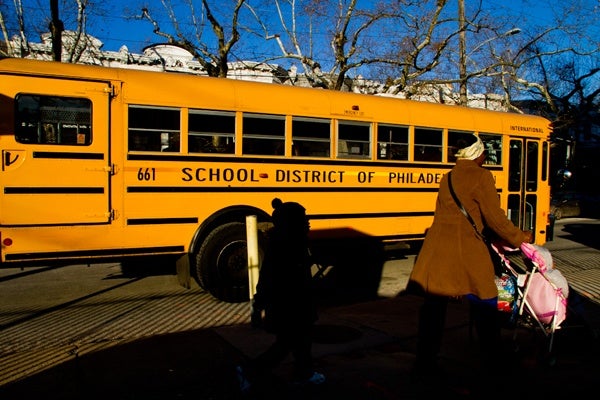 A parent walks her kids to school Thursday morning at John L. Kinsey Elementary in North Philadelphia. (Brad Larrison/for NewsWorks)