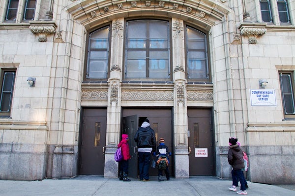 A parent walks his children into school at John L. Kinsey Elementary in North Philadelphia. The school is one of many on a list of Philadelphia Public Schools that the district plans to close at the end of the school year. (Brad Larrison/for NewsWorks)