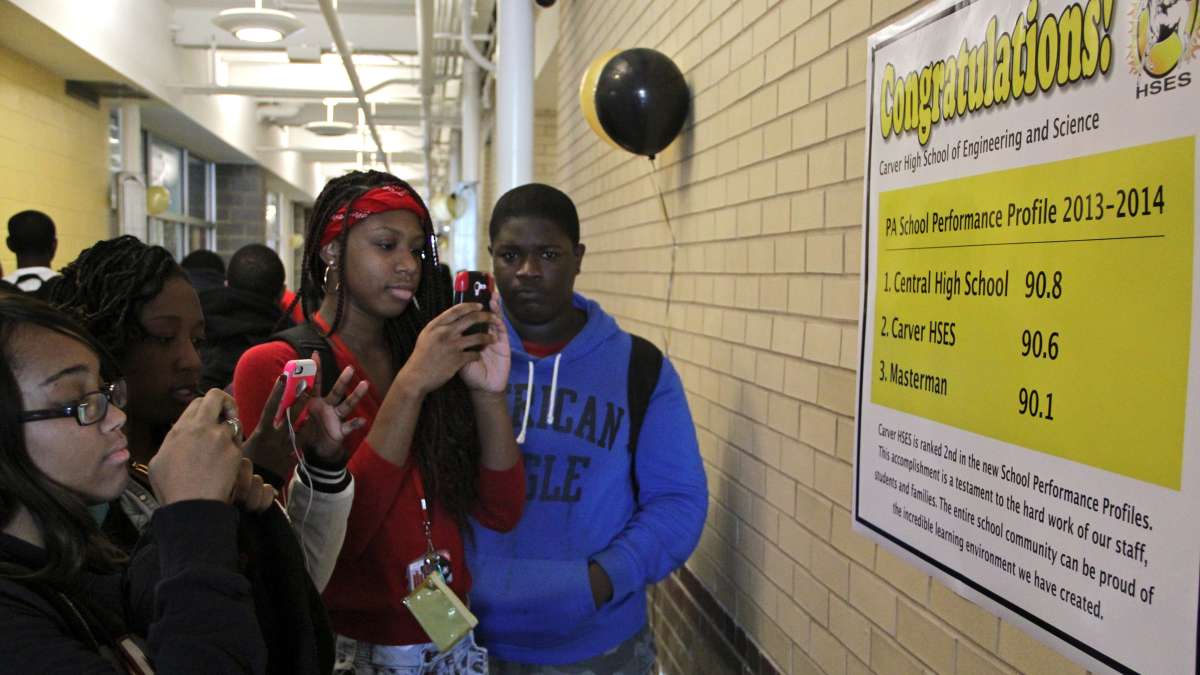 This 2014 photo shows students at Carver High School in Philadelphia stopping in the hall to photograph a poster detailing the new state rankings that place their school at No. 2 in the district. (Emma Lee/WHYY)