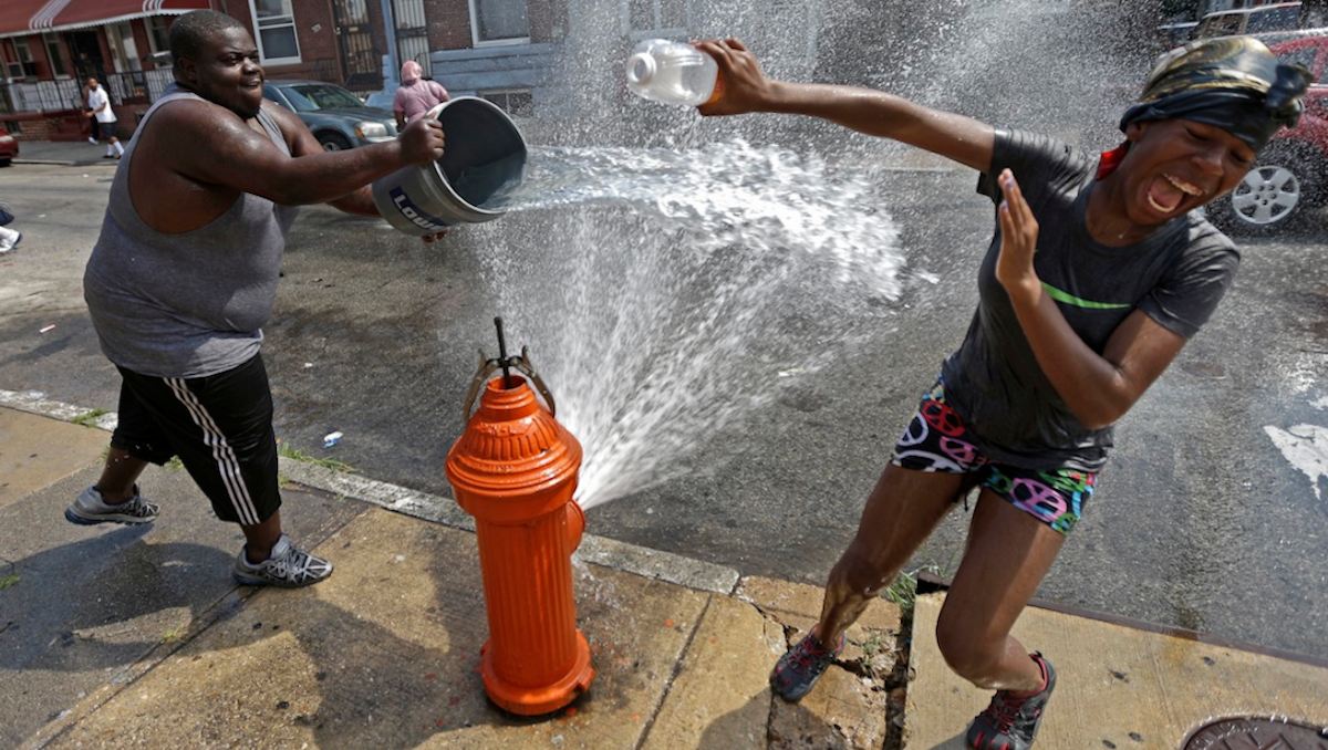  People play in water from an open fire hydrant during the afternoon heat, Wednesday, July 18, 2012, in Philadelphia. (AP Photo/Matt Rourke) 