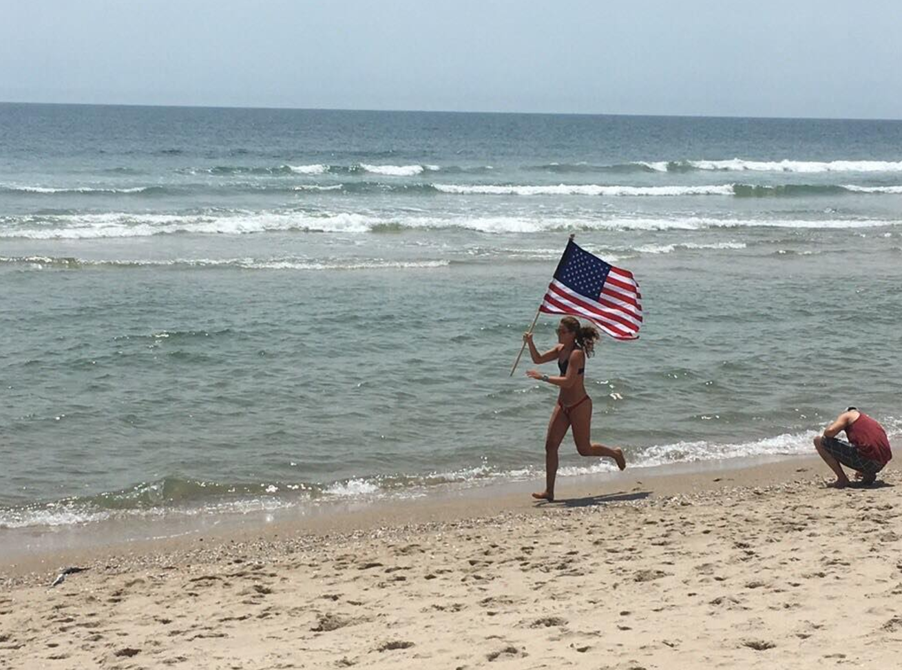 screen-shot-2017-07-05-at-2-21-54-pm A lifeguard runs the American flag along the shoreline in Long Beach Island. (Image courtesy of Bobby Lynch/Brant Beach Surf Rescue)