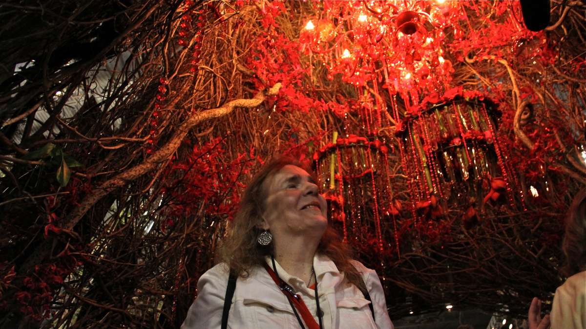 Ebba Slater stands inside the hollow of a giant redwood tree, hung with flower-draped chandeliers.