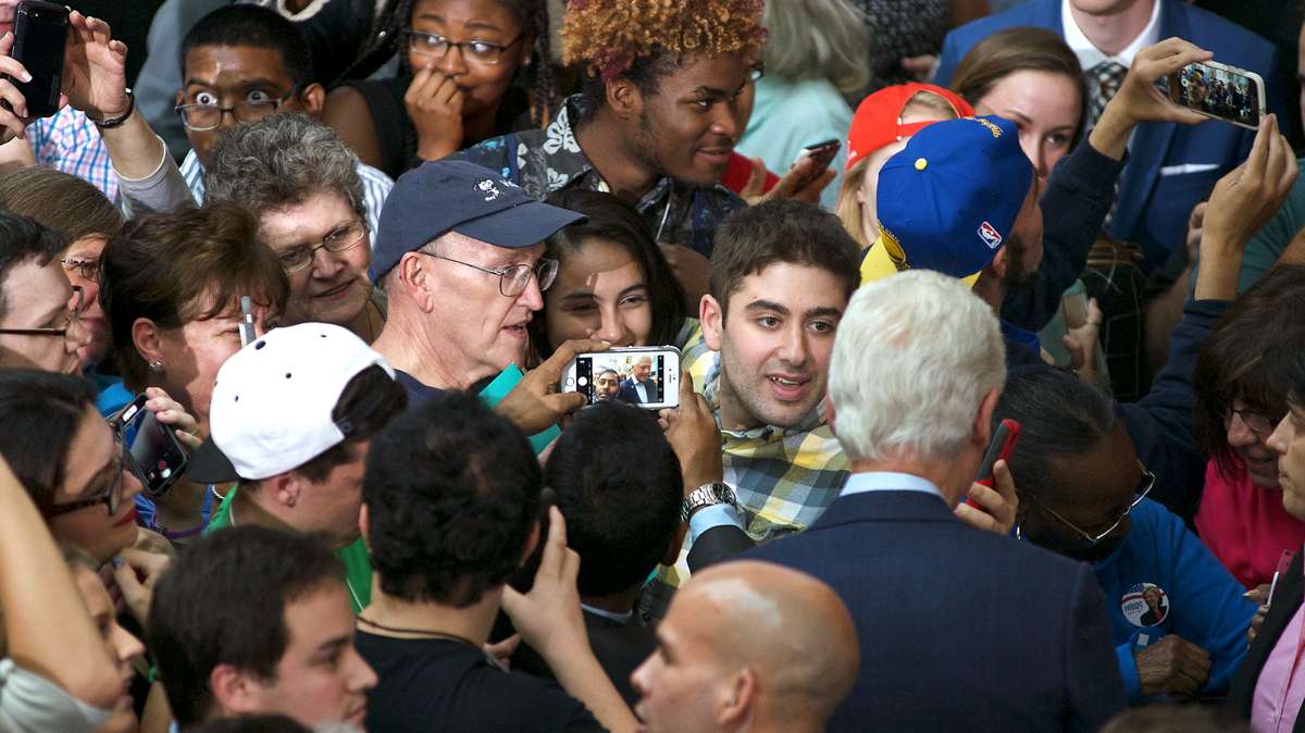 Jonathan Lee Riches, (on the right, wearing blue cap), is seen holding a phone to self-record his actions as waits at the rope line when former President Bill Clinton greets voters at a rally for Hillary Clinton at Montgomery County Community College, in Blue Bell, Pennsylvania, on Oct. 18, 2016. (Bastiaan Slabbers for NewsWorks)