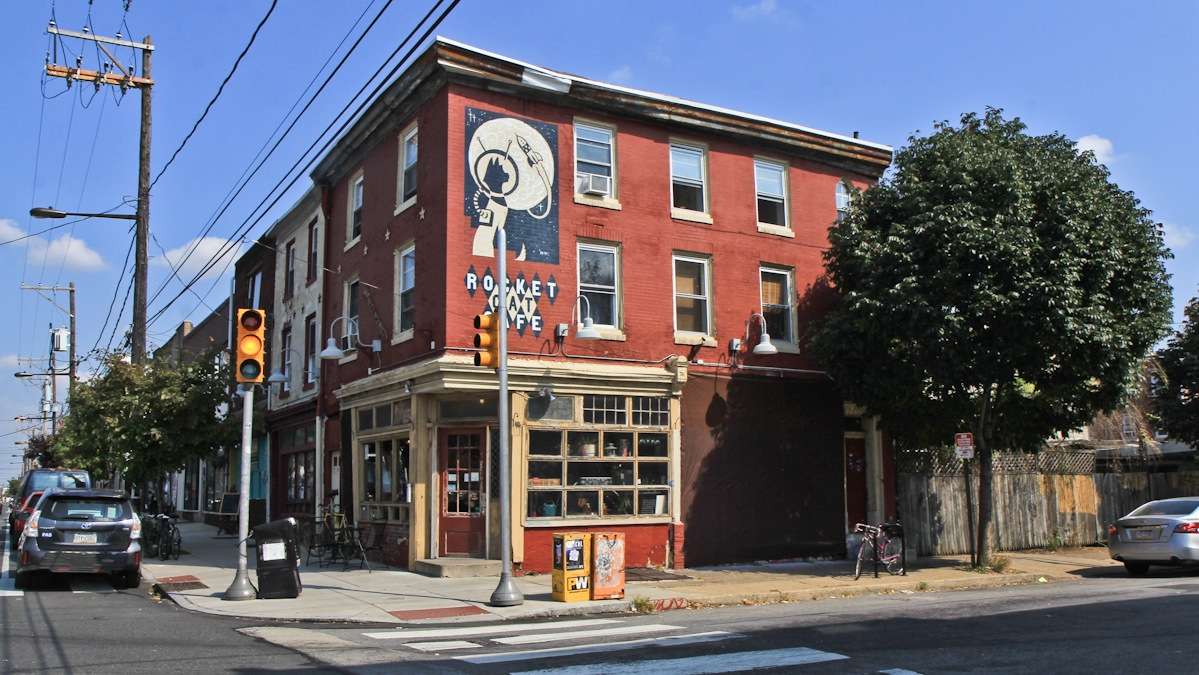 The Shepard Fairey wheatpaste on the Norris Street side of Rocket Cat Cafe went up in 2010 and is now covered with a brown tarp until owner Karen Breese decides how to revive the mural. (Kimberly Paynter/WHYY)