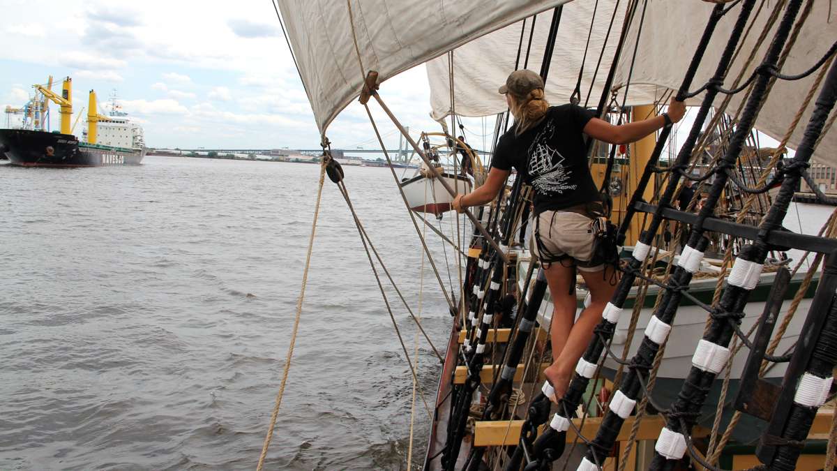 Erin Greig hangs from the rigging of the Picton Castle as she frees some lines. (Emma Lee/WHYY)