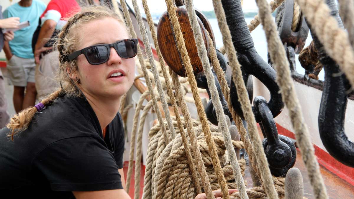 Rebecca Prasher secures the lines on the Picton Castle as it leads the Parade of Ships on the Delaware. (Emma Lee/WHYY)