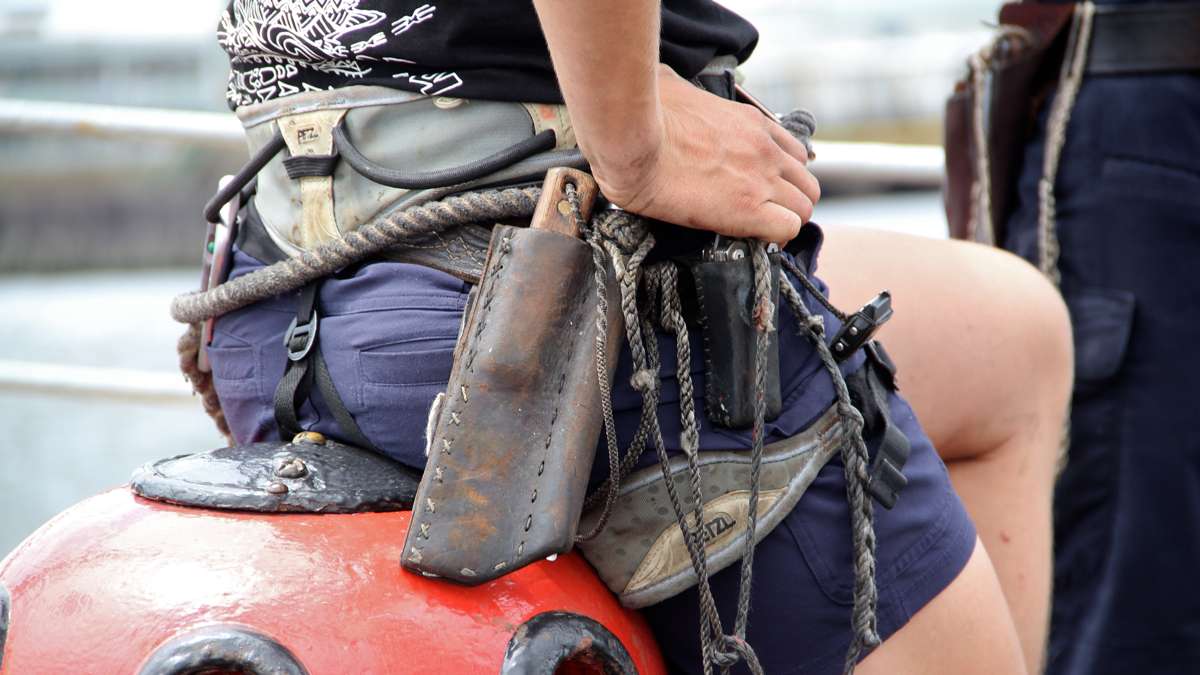 The ship's crew wear their tools everywhere, including fixed-blade knife, marlin spike and harness for security in the rigging. (Emma Lee/WHYY)