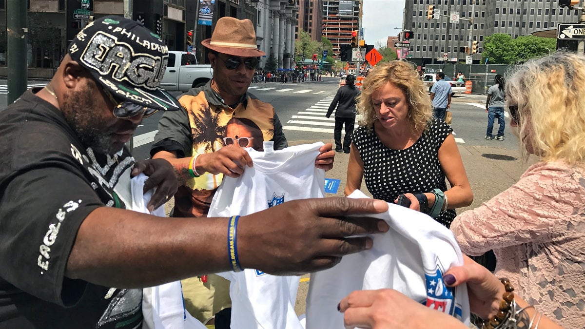  Sekou Davis and his partner Dayvon 'DayDay' Woody sell unofficial NFL Draft merchandise near City Hall as the city hosts the national football event.  (Bobby Allyn/WHYY) 