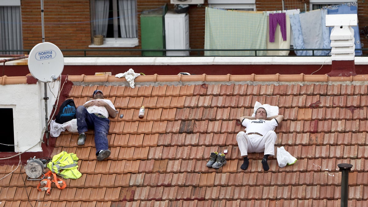  Two workers take a nap on a roof in Madrid, Spain. (AP Photo/Alberto Di Lolli, File) 