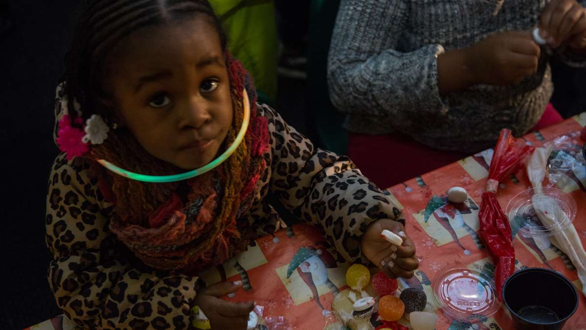 Two year old Malaya Mulligan works on her cookie creation inside the Ben's Sweets and Treats tent.