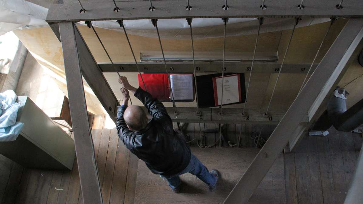 Music director Peter Hopkins rings the bells of St. Peter's using a system of ropes and pulleys. (Emma Lee/for NewsWorks)