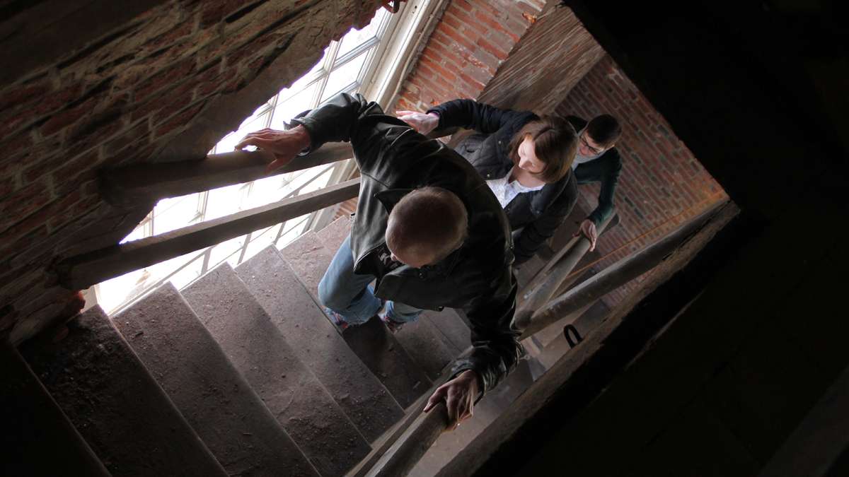 St. Peter's musical director Peter Hopkins climbs the bell tower stairs followed by communications director Lauri Cielo and parish administrator Kate Randall. (Emma Lee/for NewsWorks)